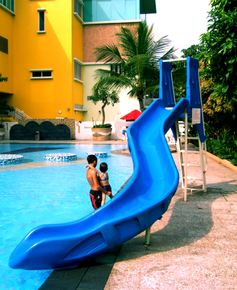 blue adams custom pool slide next to hotel in Asia.