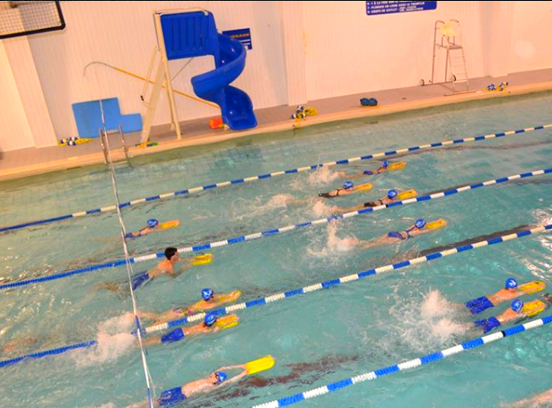 swimmers next to indoor aqua deluxe pool slide